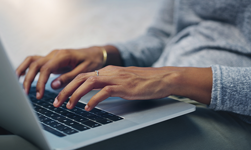 person tying on a silver laptop