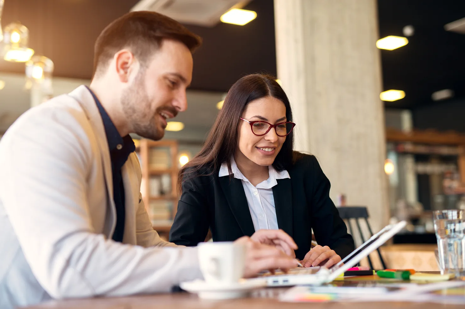 man on left showing woman on right some paperwork